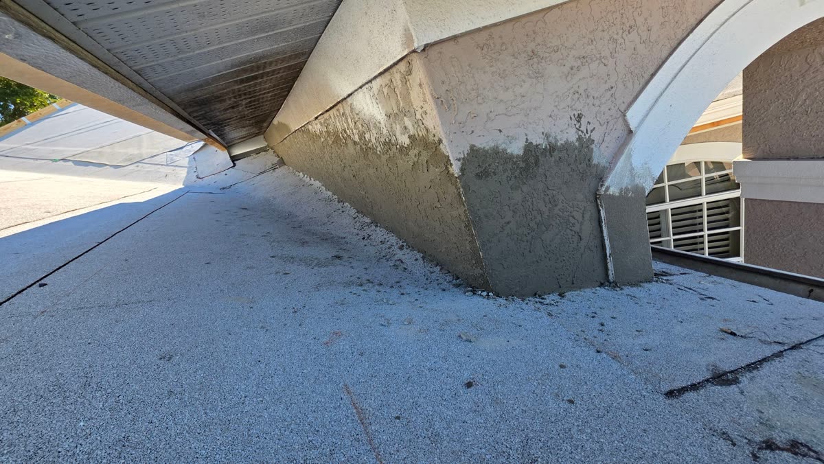 Newly replaced roof flashing at a wall transition, integrated with fresh stucco patch work